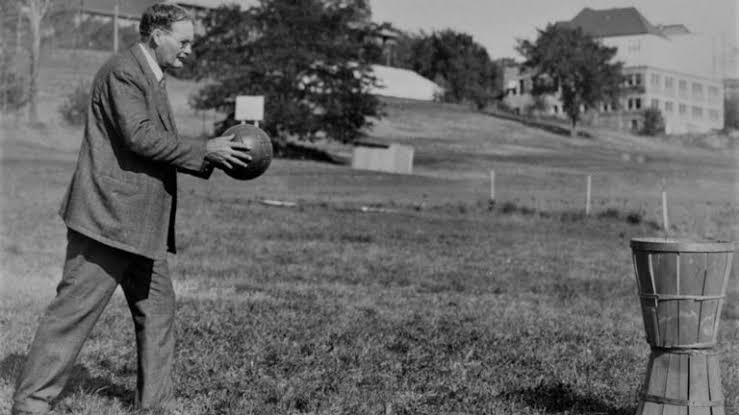 James Naismith avec ses paniers à pêche et le premier ballon de basket